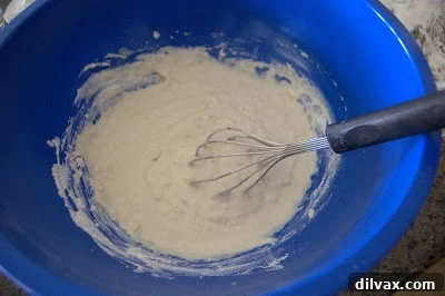 Mixing first cup of flour into the wet dough mixture