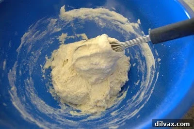 Dough coming together in a ball, pulling away from the bowl