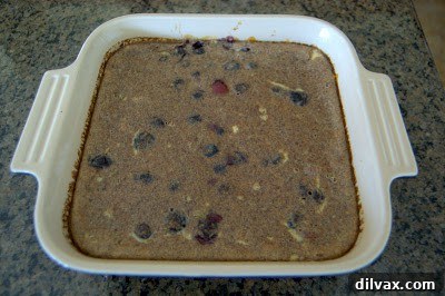 The baked rice breakfast fresh out of the oven, showing a golden-brown top and bubbling edges, still in the baking dish.