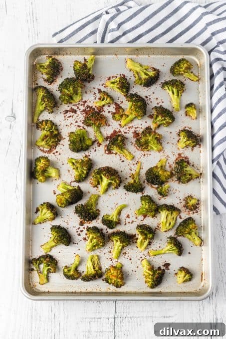 A sheet pan filled with freshly roasted, crispy broccoli