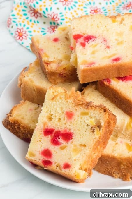 Slices of tropical quick bread with cherries, pineapple and coconut.