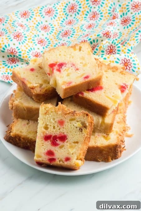 A plate of pineapple bread slices with cherries and coconut.