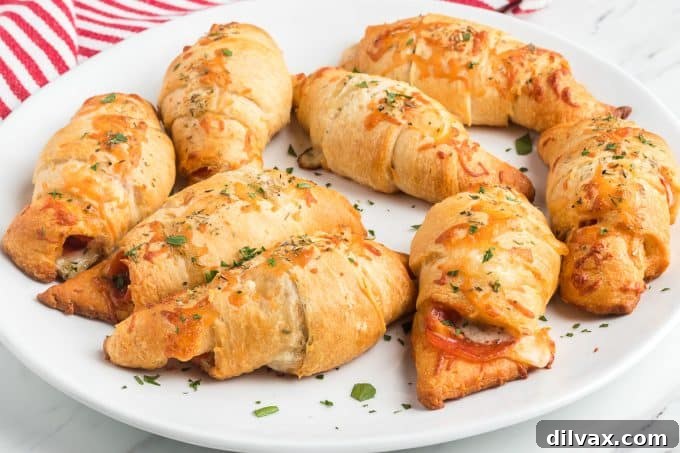 Effortless Pepperoni Crescent Rolls 2 Golden brown Pepperoni Crescent Rolls on a plate, showcasing their flaky crust and a hint of melted cheese.