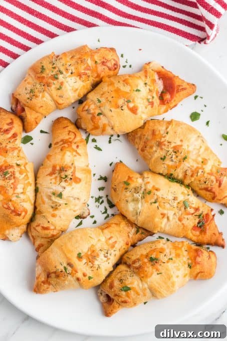 Effortless Pepperoni Crescent Rolls 7 A beautifully plated assortment of crescent rolls, bursting with pepperoni and melted mozzarella cheese.
