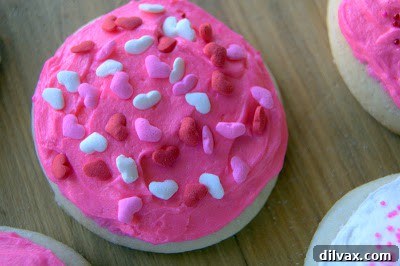 Freshly baked soft frosted sugar cookies on a cooling rack, ready for the next step.