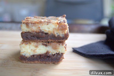 A close-up of a perfectly cut cream cheese brownie with a visible swirled pattern and peanut butter chips.