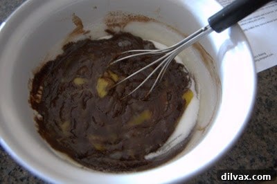 Gently folding flour into the brownie batter until just combined.