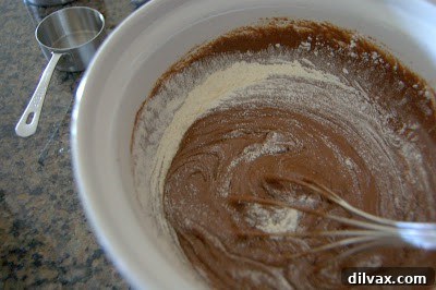 Spreading three-quarters of the brownie batter evenly into the prepared baking pan.