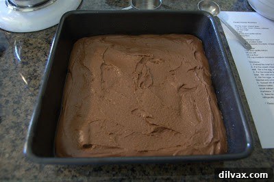 Dropping spoonfuls of cream cheese mixture over the brownie batter in the pan.
