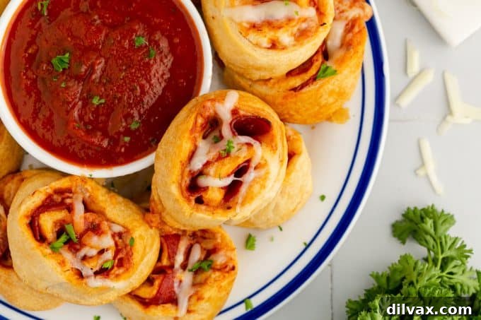Golden brown pepperoni pizza pinwheels on a baking sheet, ready to be served.