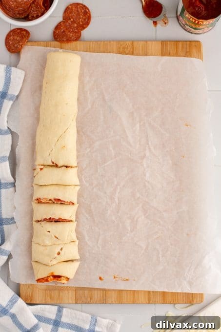 Cheesy Pepperoni Pizza Spirals 6 Slicing crescent dough pinwheels after filling