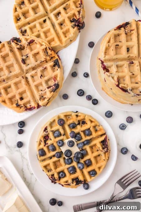 A stack of golden, fresh blueberry waffles ready for breakfast.