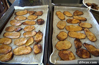 Baked taco chips cooking on a baking sheet, some already turning golden brown