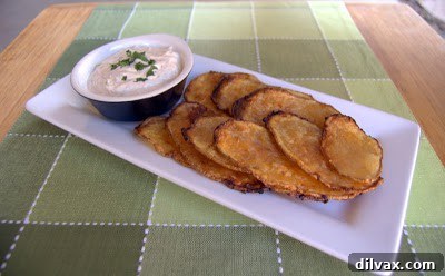 Close-up of golden brown baked taco chips with chili-cilantro dipping sauce