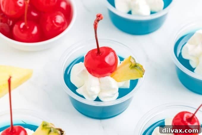 Whip Up Blue Hawaiian Jello Shots 2 Vibrant Blue Hawaiian Jello Shots garnished with pineapple and cherries