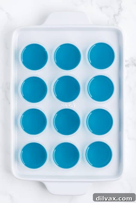 Whip Up Blue Hawaiian Jello Shots 6 Blue jello shots arranged on a tray, ready to be chilled.