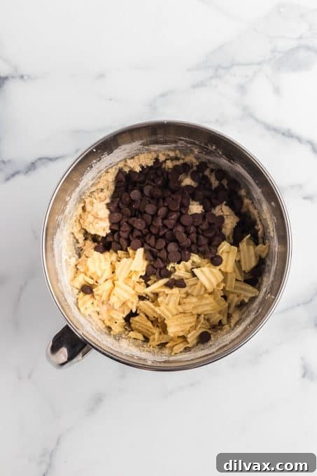 Crispy Salty Sweet Chocolate Chip Cookies 6 Cookie dough with chocolate chips and potato chips, ready for mixing.