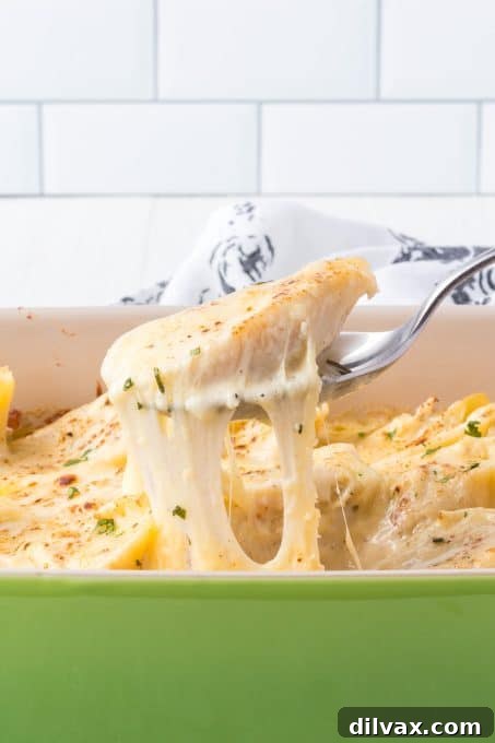 Pulling a shell and cheese out of a casserole dish with a serving spoon.