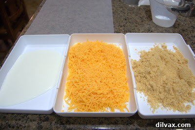 Crispy Cheddar Chicken Day 319 3 Three bowls set up for dredging chicken: buttermilk, shredded cheddar cheese, and Ritz cracker crumbs.