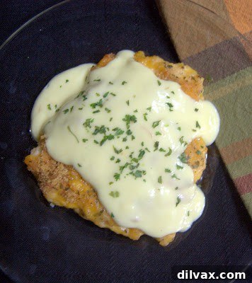 Crispy Cheddar Chicken Day 319 7 A close-up shot of a single piece of Crispy Cheddar Chicken with a rich cream sauce drizzled over it.