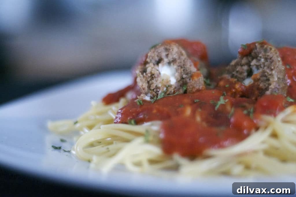 A dish of freshly baked Mozzarella Stuffed Meatballs with parsley garnish