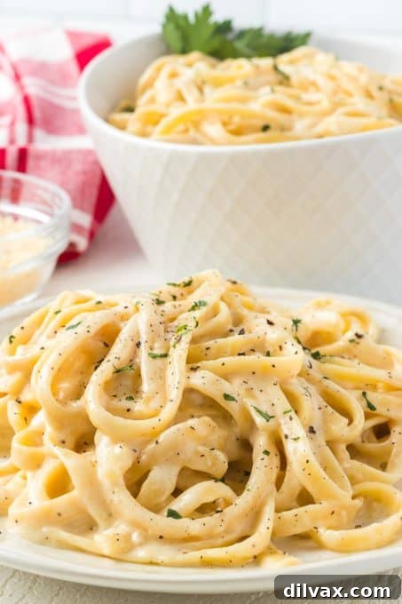 Velvety Garlic Alfredo Fettuccine 3 Homemade Alfredo sauce generously coating fettuccine noodles in a serving bowl