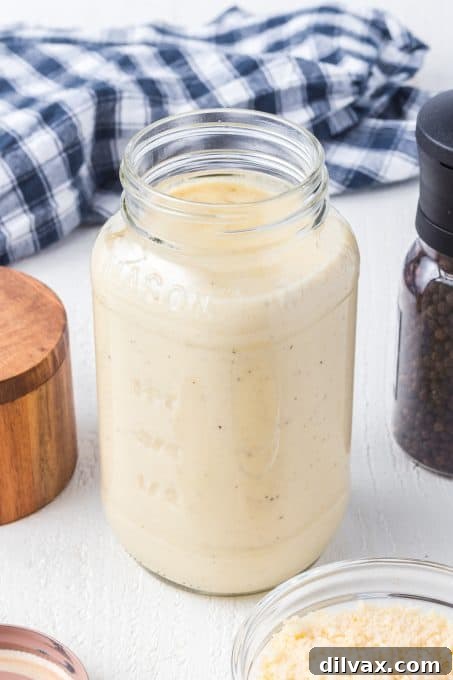 Velvety Garlic Alfredo Fettuccine 5 Close-up of a creamy, rich Alfredo sauce with visible flecks of roasted garlic