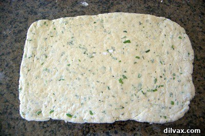 Rolling out the dough into a 9x13-inch rectangle on a lightly floured surface.