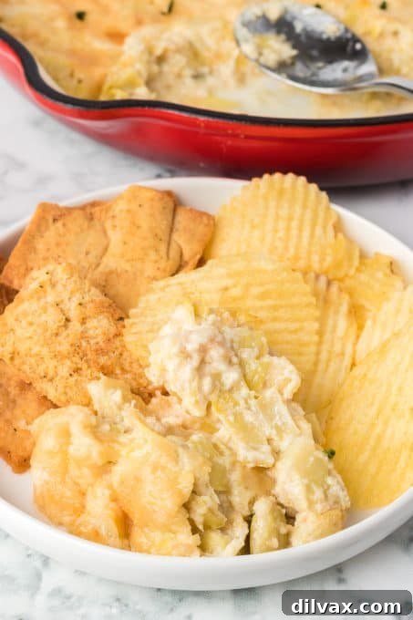 Baked Artichoke Dip with assorted dippers, ready for a party.