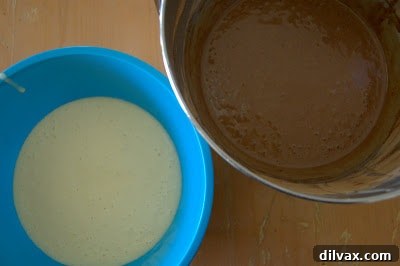 Cocoa powder being sifted into a bowl of batter