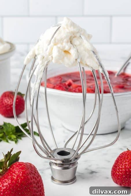 A whisk attachment with perfectly whipped cream, ready for shortcake.