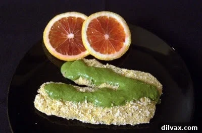 A beautifully plated dish of golden-brown breaded tilapia, accompanied by a side of bright green cilantro citrus sauce, ready to be enjoyed.