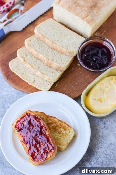 Nook and Cranny Loaf 3 A freshly baked loaf of English Muffin Bread, expertly toasted and generously spread with vibrant berry jam.