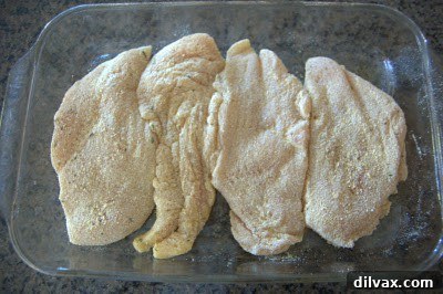 Savory Mustard Pecan Chicken 3 Coated chicken breasts arranged in a baking dish.
