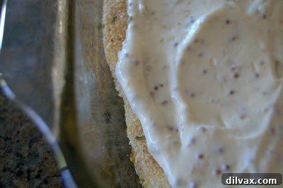 Savory Mustard Pecan Chicken 4 Mayonnaise and mustard mixture being spread over chicken breasts in a baking dish.