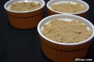 Crème Brûlée with sugar being caramelized by a kitchen torch