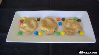Freshly baked M&M cookies cooling on a wire rack.