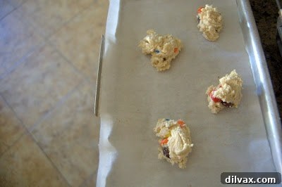 Cookie dough balls neatly arranged on a parchment-lined baking sheet.