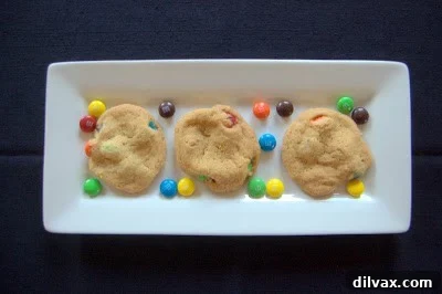 Freshly baked M&M cookies cooling on a wire rack.