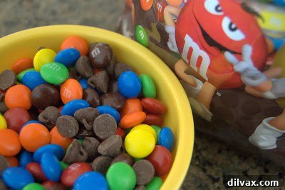 A bowl filled with colorful M&Ms, ready to be incorporated into cookie dough.