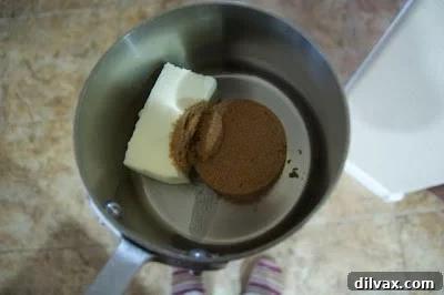 Saucepan with butter and dark brown sugar mixture bubbling on the stove, beginning to caramelize