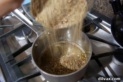 Day 293: A Sticky Letdown 4 Toffee mixture, now with all pecans, being poured into a baking pan
