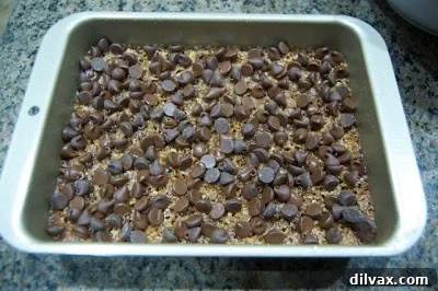 Melted chocolate spread smoothly and evenly over the toffee base with nuts, creating a finished top layer