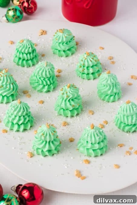 Green meringues shaped and decorated as Christmas trees.