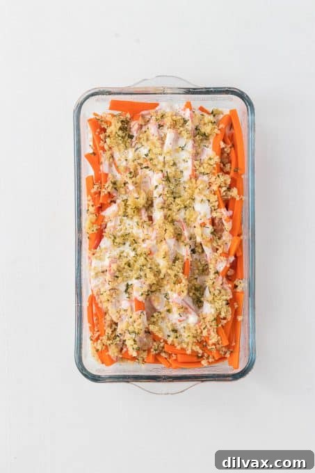 Carrots generously coated with creamy horseradish sauce and crispy Panko topping, ready for baking.