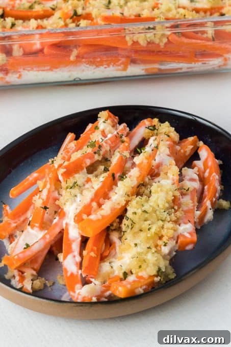 Julienned carrots topped with creamy horseradish sauce and crispy bread crumbs before baking, in a baking dish.