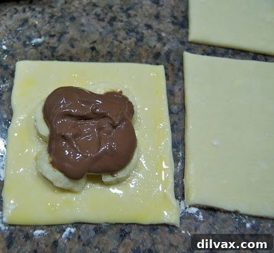 Banana slices and Nutella spread on a pastry square.