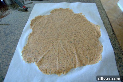 Cracker dough on a baking sheet, cut into squares before baking.