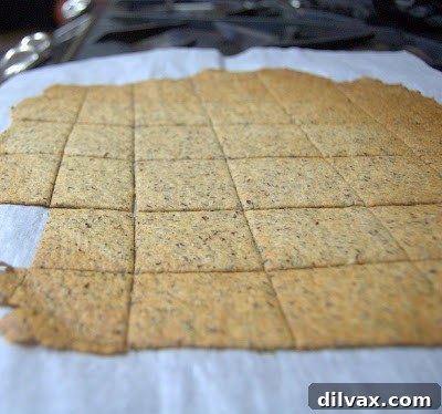 A batch of golden brown homemade wheat crackers, cooling on a wire rack after baking.