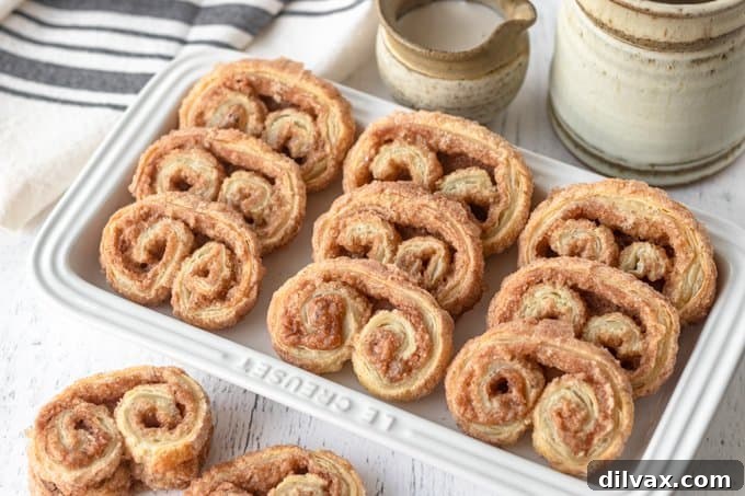 Golden brown Cinnamon Sugar Palmiers stacked on a white plate